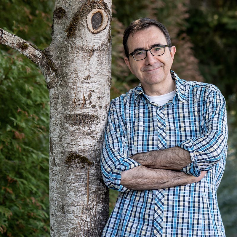 Jeanyves, cofounder of Chocolat-e, stands against a tree smiling.