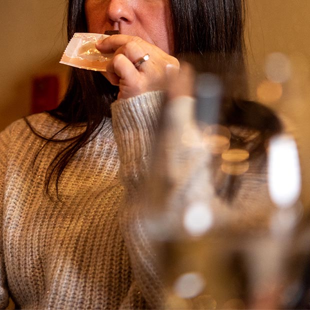 Close-up of a person smelling the bite of Chocolat-e gourmet chocolate.