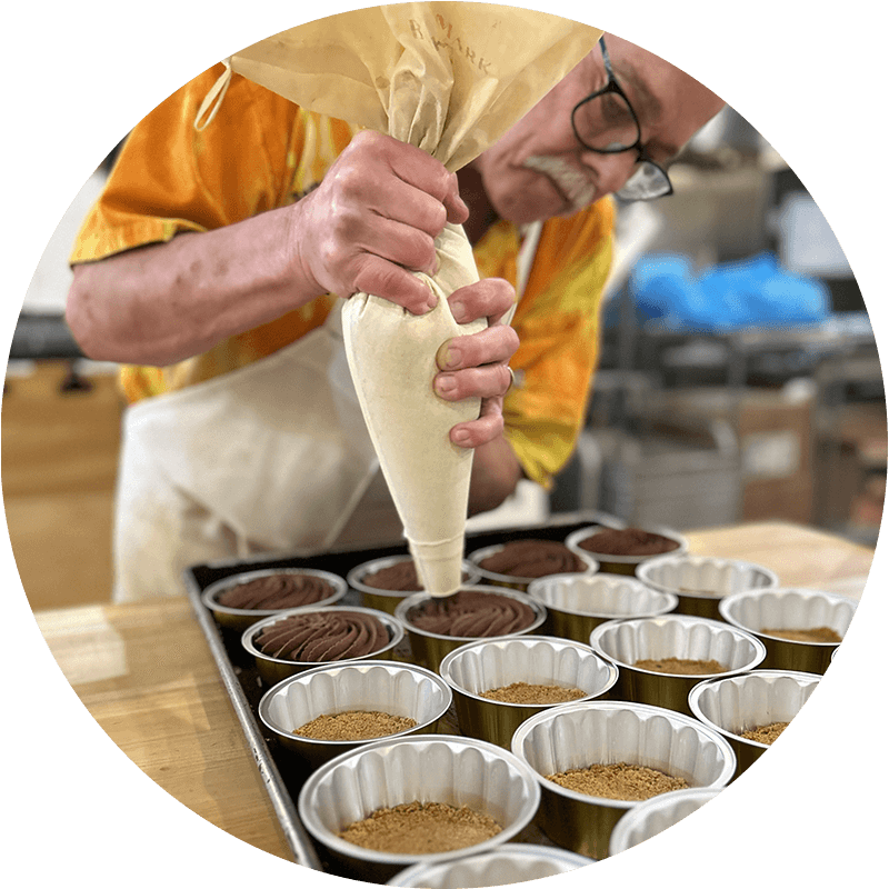 Ray Degele, owner and baker at the Depoe Baykery, is piping chocolate.