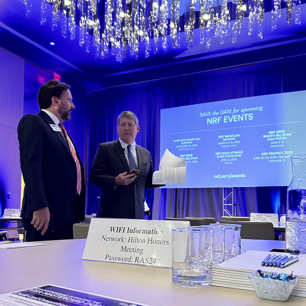 Two people are preparing to talk at the National Retail Foundation event.