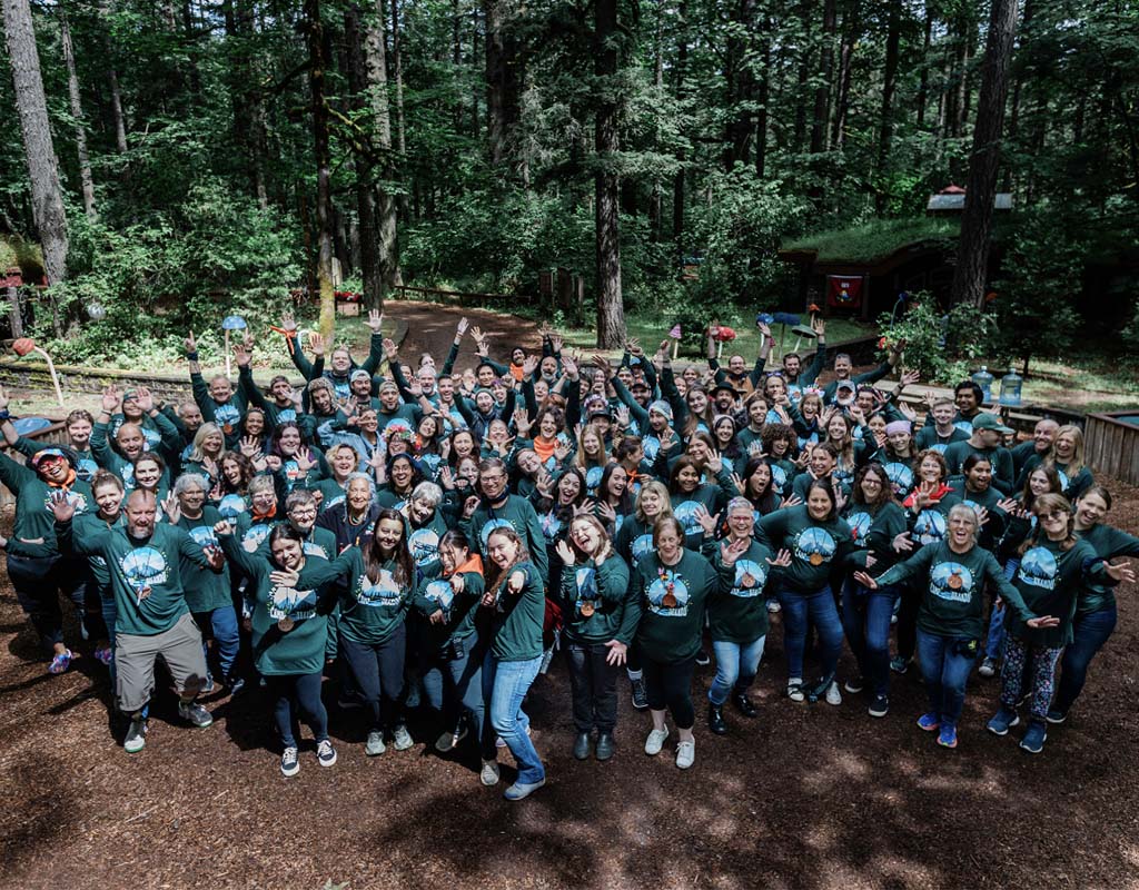 A large group of people, all wearing the same dark green shirt, represent UKANDU.