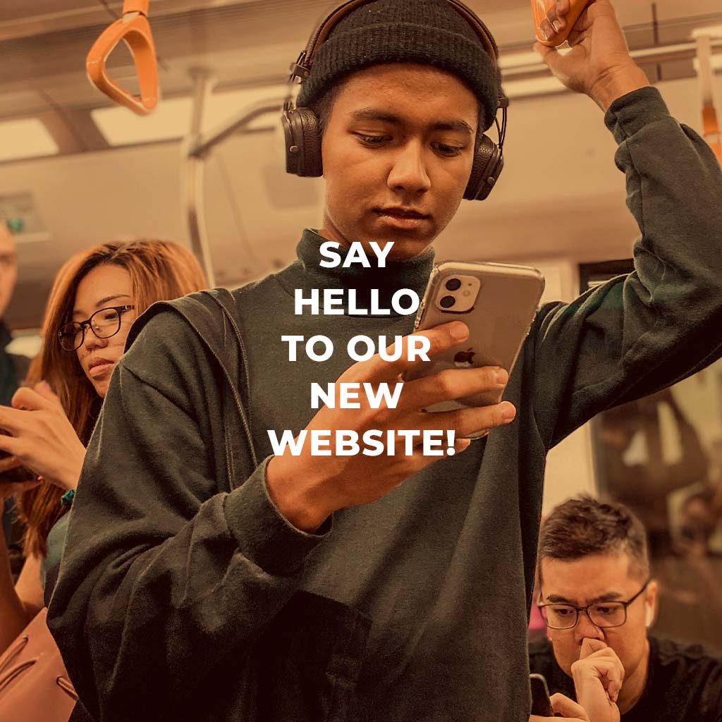 Say hello to our new website. A person is on their phone in the subway.